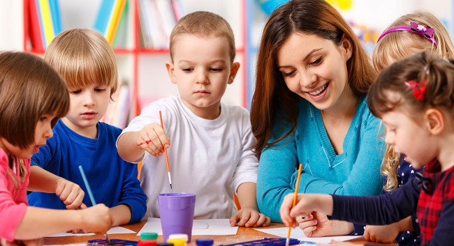 澳洲幼教留学课堂场景，幼教老师正在带领一群儿童进行绘画活动，体现澳洲早教课程的实践教学氛围。